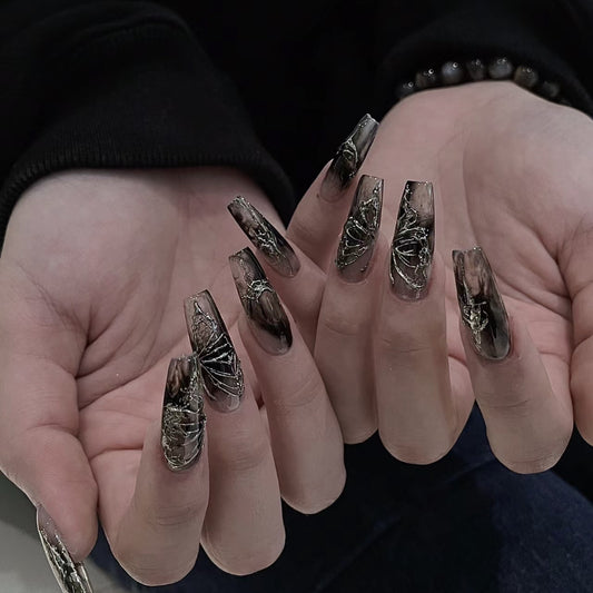 Close-up of hands with decorative nail art on a dark background