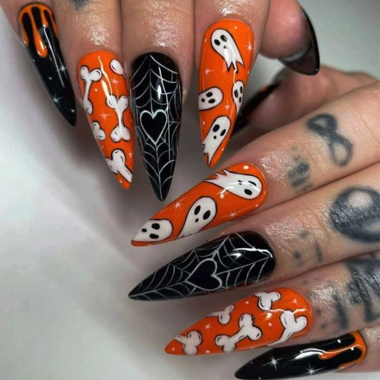 Halloween-themed nail art with orange, black, and white designs on a neutral background.
