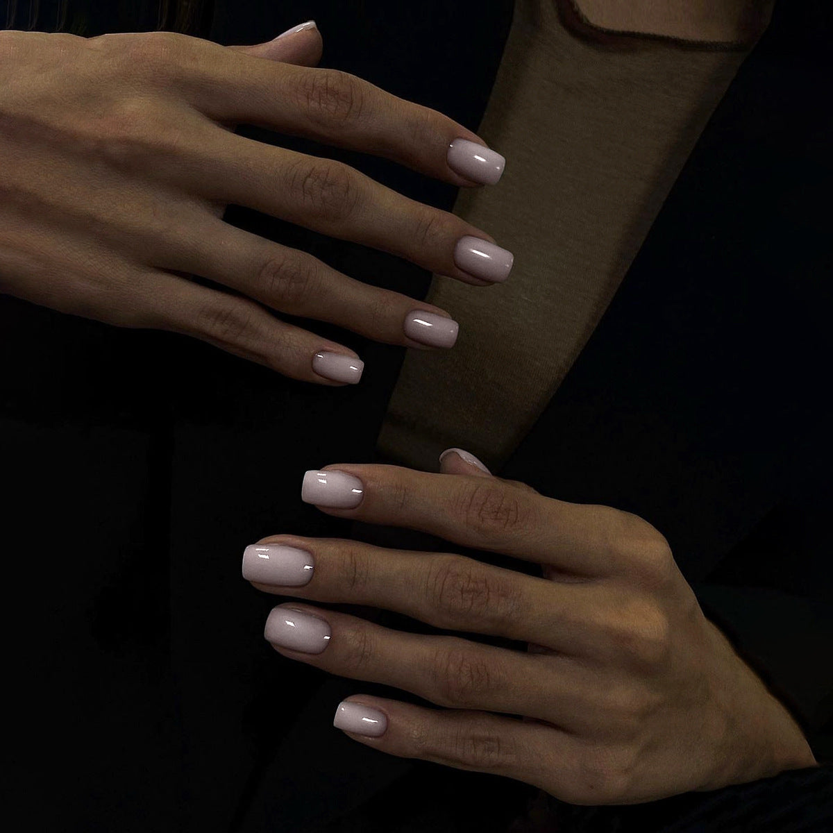 A pair of short square-shaped, soft pink press-on nails with a glossy finish.