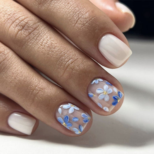 A set of press-on nails featuring a floral design with blue and beige colors.