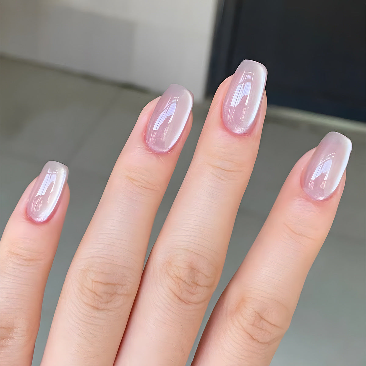 A person's fingers showcasing long square press-on nails with a glossy finish and a lavender ombre effect.