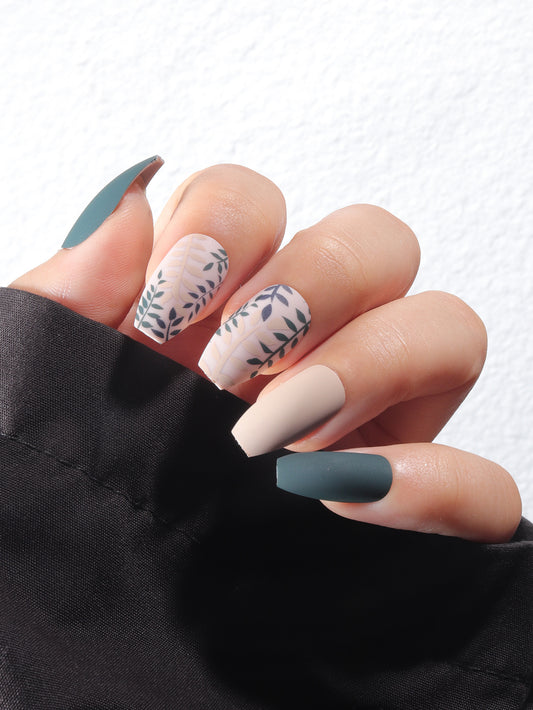 Close-up of a hand with painted nails featuring a mix of colors and patterns.
