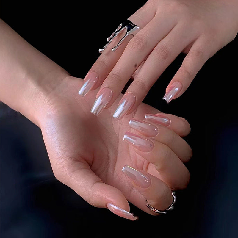 Close-up of two hands with clear nail polish on a dark background