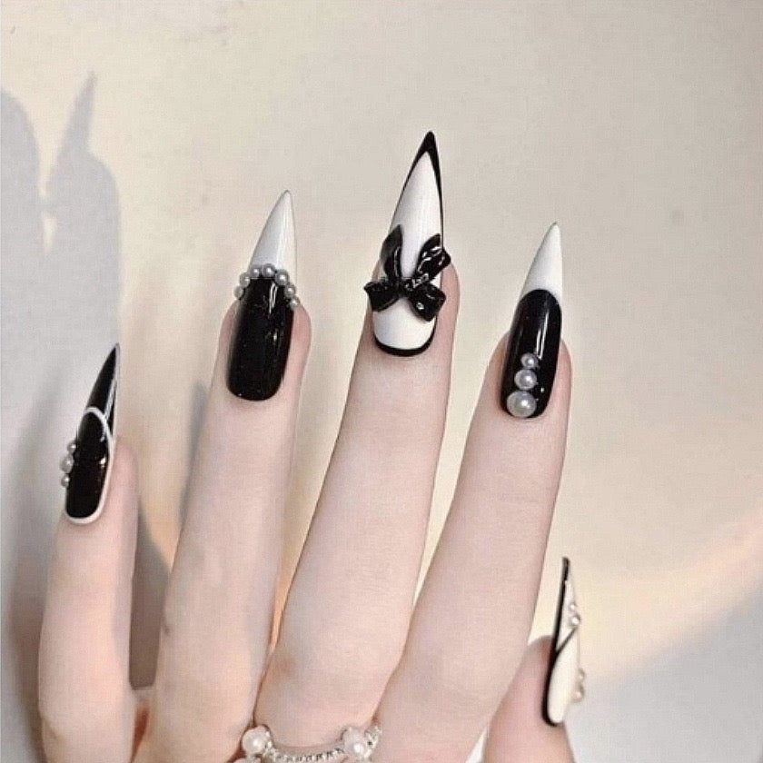 Elegant Monochrome Extra Long Pointed Press-On Nails with Glossy Black and White Design, Pearl Embellishments, and Bow Accents