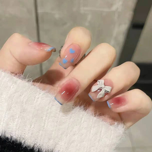 Whimsical Winter Medium Square Press on Nail Set in Sheer Pink with Blue Tips, Heart Patterns, and 3D Bow Accent