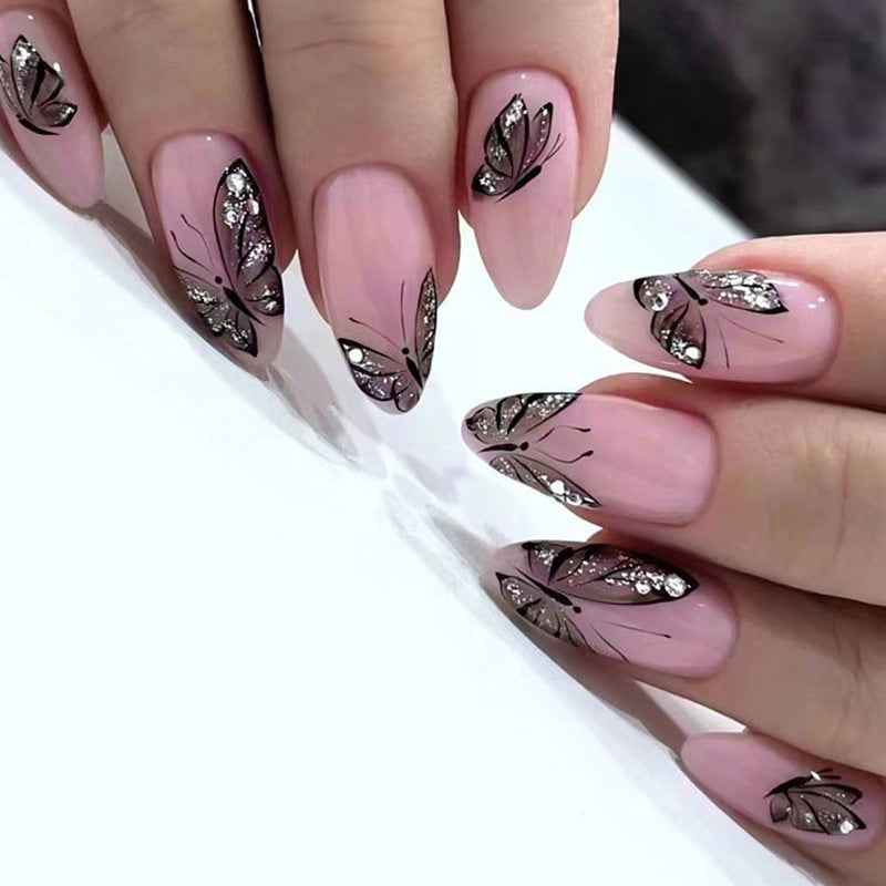 Nails with pink polish and butterfly designs on a white background