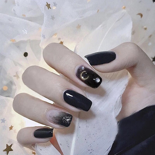 Hand with black nail polish and decorative elements on a starry background